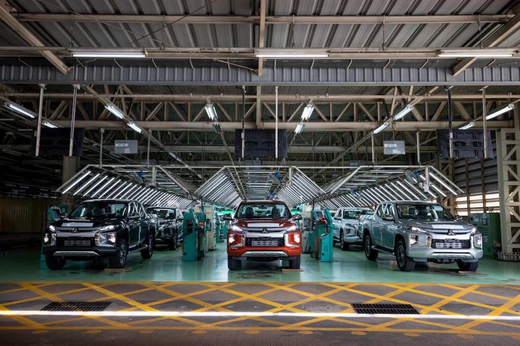 A line of new Mitsubishi Tritons in a warehouse