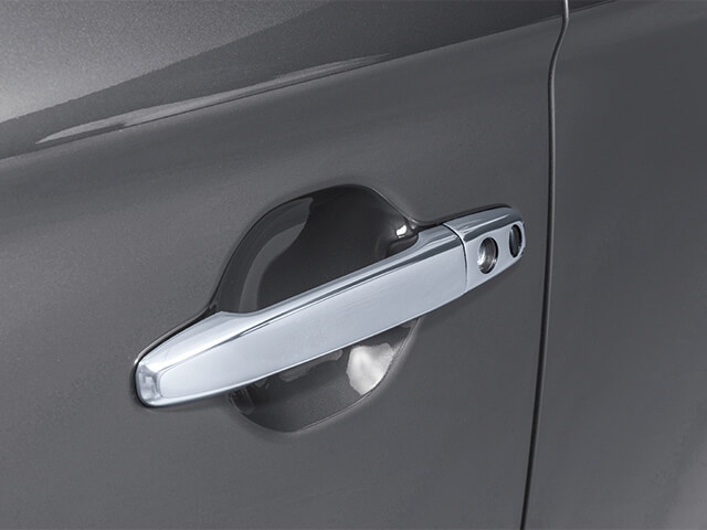 Close up photo of chrome door handle on dark grey car body.