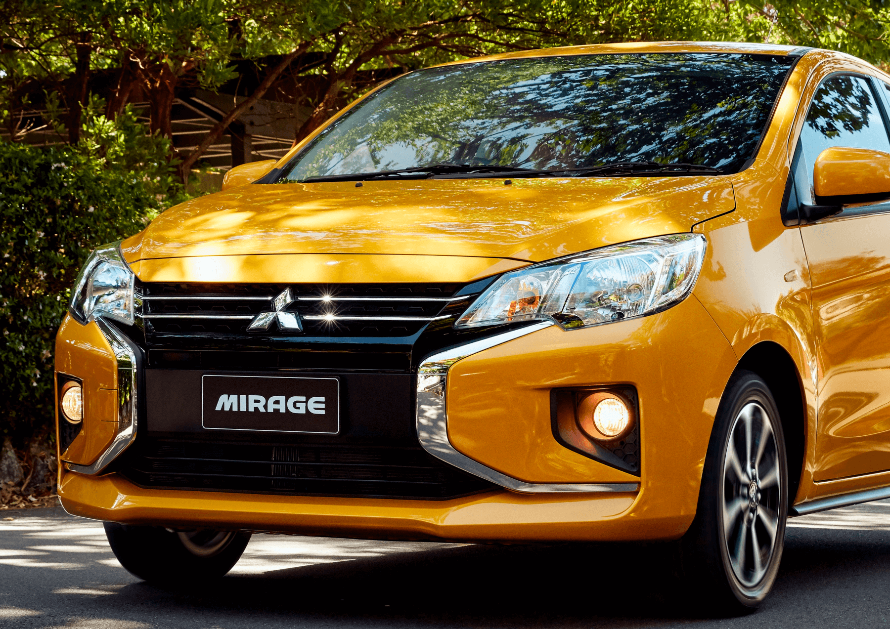Shot of the front of a yellow Mitsubishi Mirage at park