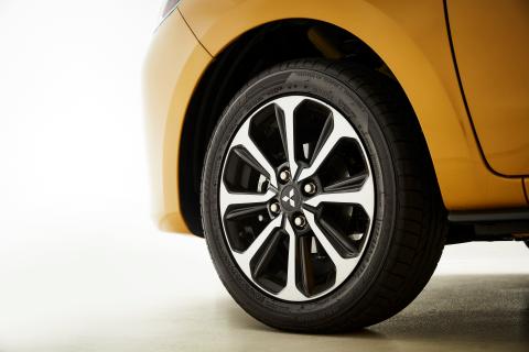 A close up shot of left side front wheel of a yellow Mitsubishi Mirage