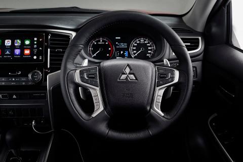 The interior of a Mitsubishi Triton showing the steering wheel and dashboard
